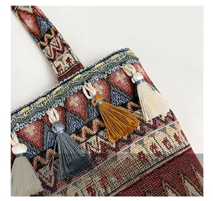 Detail of ethnic jacquard weave bag featuring colorful tassels and braided lace edges