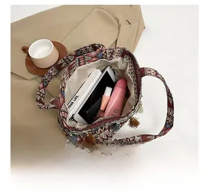 Spacious interior of ethnic tote bag showing daily items and colorful tassels