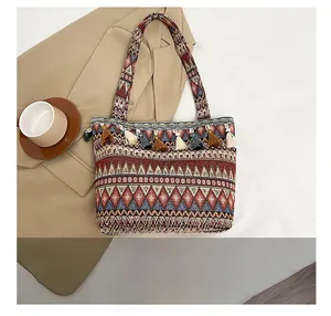 Macro detail of Bohemian woven tote bag with colorful geometric patterns and decorative tassels