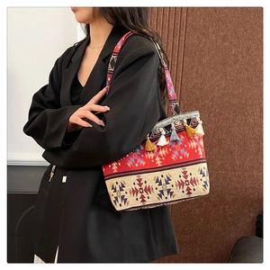 Close-up of ethnic style woven tote bag featuring colorful fringe and patterns