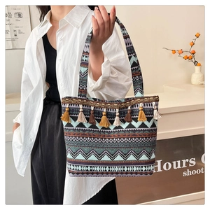 Detail of colorful woven tote bag featuring ethnic patterns and decorative fringe accents