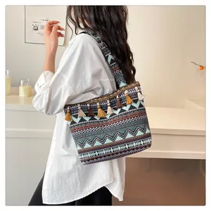 Close-up of bohemian canvas tote featuring ethnic geometric patterns and colorful tassels