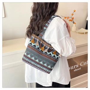 Detail of bohemian tote bag featuring ethnic geometric patterns and colorful tassels