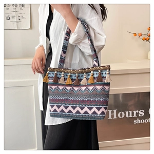 Detail of ethnic tote bag with woven wave patterns and colorful decorative tassels