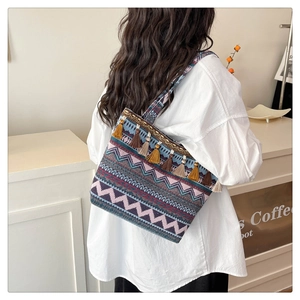 Detail of bohemian woven tote bag featuring colorful geometric patterns and fringe tassels