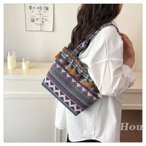 Detail of bohemian tote bag featuring geometric embroidery and colorful tassel fringe
