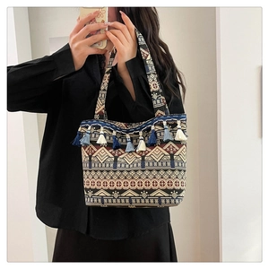 Detail of ethnic jacquard tote bag featuring bohemian patterns and colorful fringe tassels