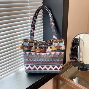 Ethnic style woven tote bag with colorful geometric patterns and decorative tassels