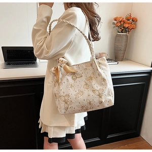 Detail of white butterfly print tote bag with champagne silk scarf on woven handle