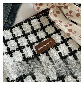 Detailed macro view of houndstooth tweed fabric texture with brown leather logo patch