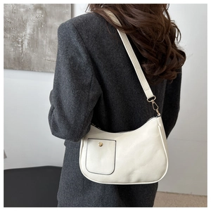 Détail d'un sac à bandoulière en cuir PU beige minimaliste avec boucle dorée sur modèle
