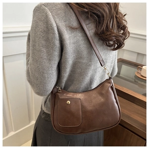 Gros plan du sac porté épaule marron rétro avec boucle dorée et tenue décontractée