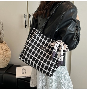 Plaid tweed tote bag with chain strap and silk scarf detail worn by fashion model