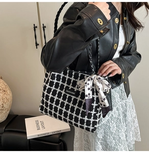 Detail of checkered wool tote bag with polka dot scarf and woven handles