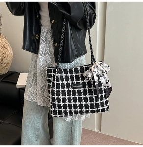 Detail of checkered tweed tote bag featuring black and white pattern with silk scarf deco