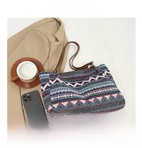 Detailed macro view of ethnic woven tote bag with zig-zag pattern and brown leather straps