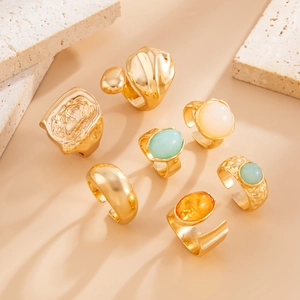 Detail of 7-piece vintage gold ring set with colorful oval stones and lava textures