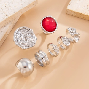 Détail d'une bague rose argentée et d'une pierre rouge d'un ensemble de 7 bijoux