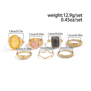 Seven-piece gold alloy ring set with acrylic stones and textured bands, various sizes