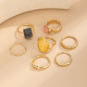 Detail view of 7pcs gold ring set featuring amber yellow and marble grey gemstones