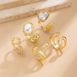 Detailed view of 5-piece gold droplet ring set with baroque pearls on stone