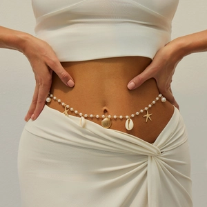 Detail of bohemian pearl belly chain with golden starfish and seashell charms on model