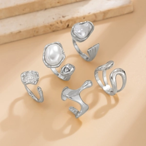 Détails d'un lot de 5 bagues argentées avec perles baroques et pierres brillantes