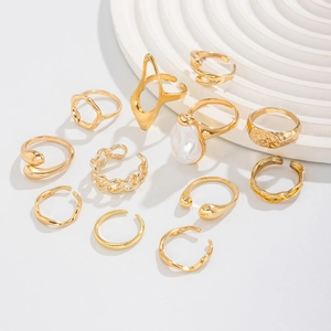 Close-up of 12-piece gold geometric ring set featuring baroque pearls and textures