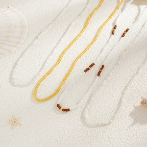 Close-up of summer ocean style waist chains with starfish and shells on sand