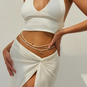 Détail de la chaîne de taille avec perles blanches et pendentif étoile de mer