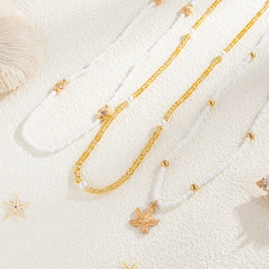Vue détaillée de colliers en perles océan avec pendentifs étoile de mer et coquillage