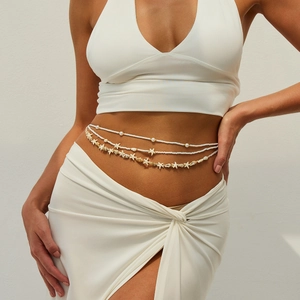 Close-up of bohemian waist chain with white beads, starfish charms and natural seashells