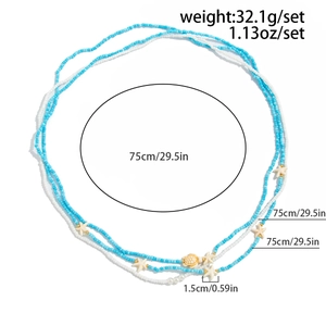 Détail des pendentifs étoile de mer et tortue sur chaîne de taille perlée, long 75 cm