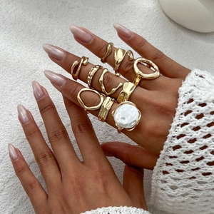 Detail eines 10-teiligen goldenen Ring-Sets mit Barockperle an der Hand