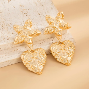 Macro shot of gold floral heart earrings featuring unique hammered liquid metal textures
