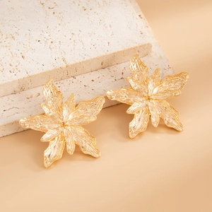 Detailed view of layered gold flower stud earrings with irregular petal textures
