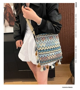 Détail d'un sac à bandoulière tissé bohème avec motifs géométriques et longues franges