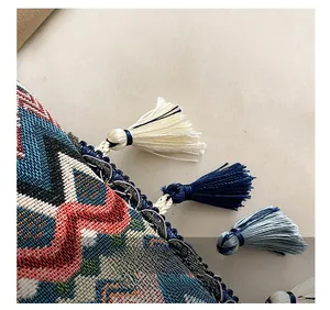 Détails de sac bandoulière tissé ethnique avec motifs géométriques colorés et finitions à franges
