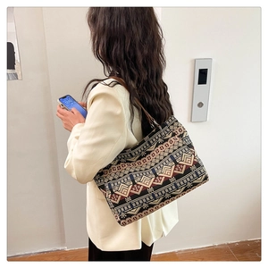 Detailed back view of a large ethnic print tote bag with brown leather shoulder straps