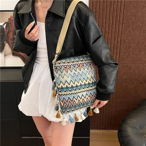 Détail du sac bohème tissé avec des franges colorées et une large bandoulière textile