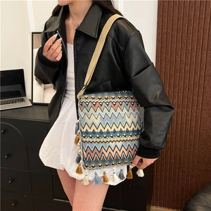 Détail du sac bandoulière tissé bohème avec motifs à vagues colorés et pompons à franges