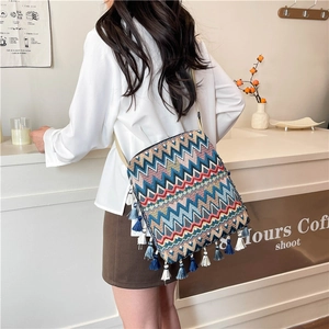Détail d'un sac bohème rétro avec tissage chevron coloré et finitions à franges bleues