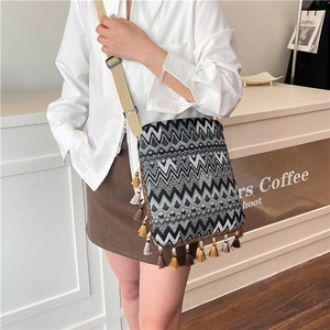 Détail du sac bandoulière tricoté à motifs ondulés avec franges et sangle réglable