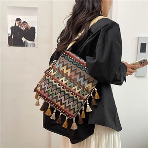 Détail d'un sac bandoulière bohème tissé coloré avec motifs ethniques et franges vives