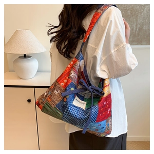 Detail view of large patchwork canvas tote bag with tie-up straps and brand label