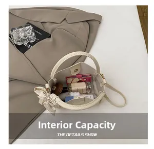 Top view of cream bucket bag interior showing capacity for cosmetics and card holder
