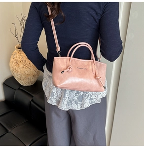 Détail du sac cabas en cuir souple rose avec doubles poignées et nœuds décoratifs