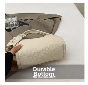 Close-up of wear-resistant bottom on cream bucket bag with lychee texture finish