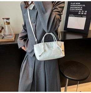 Sac cabas blanc en cuir souple avec texte Fashion Bag porté sur un costume gris