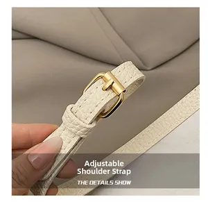 Detail of adjustable cream faux leather strap with golden metal buckle for bucket bag